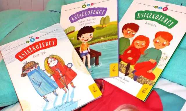 Trzy okładki książek z serii "Książkożercy" na miękkim, turkusowym tle. Dwie dziewczynki i chłopiec, bohaterowie przygód, zapraszają do czytania.
