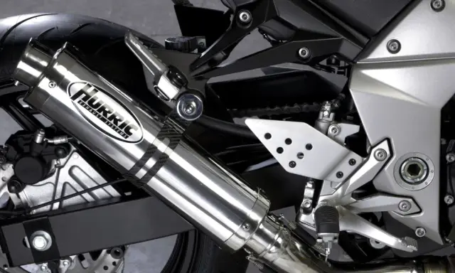 Błyszczący tłumik motocyklowy Hurric, element układu wydechowego, który może pomóc w uzyskaniu basowego brzmienia.
