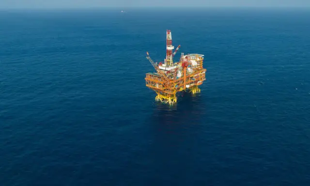 Plateforme pétrolière jackup isolée sur une mer bleue calme.