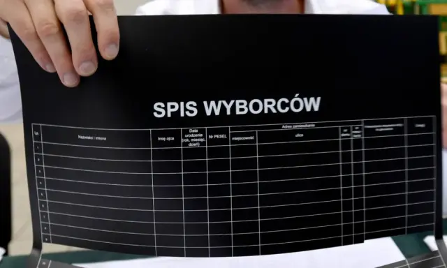 Ręce trzymają czarny arkusz z napisem "SPIS WYBORCÓW". Widać kolumny do wpisania danych, co może pomóc w procesie jak zmienic miejsce glosowania.