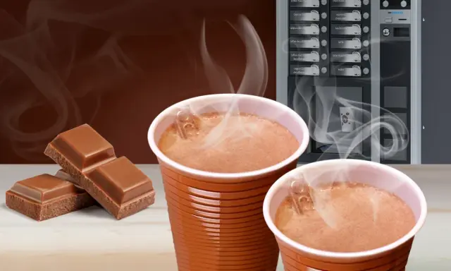 Ciepła czekolada z automatu, obok kostki czekolady. Zastanawiasz się, ile kcal ma czekolada z automatu?
