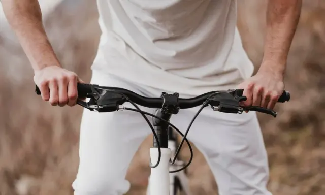 Dłonie na kierownicy roweru szosowego. Zastanawiasz się, jak dobrać szerokość kierownicy szosowej?