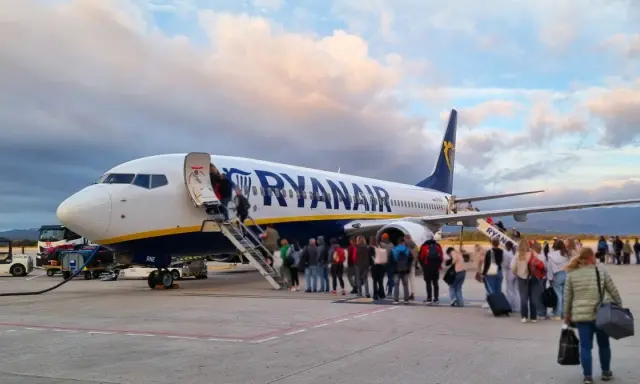 Samolot Ryanair z pasażerami wchodzącymi po schodach na pokład.