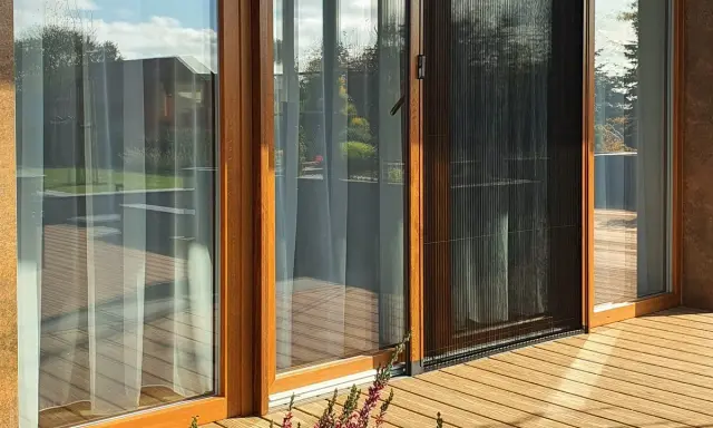 Złożona moskitiera na drzwiach balkonowych, pokazująca, jak zamontować moskitierę na drzwi balkonowe, chroniąc przed owadami.