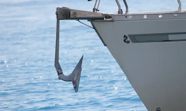 Ancre de bateau suspendue à la proue, prête pour l'action. Une image qui illustre comment remonter une ancre de bateau.