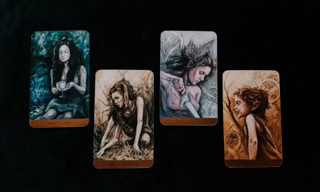 Cztery karty tarota: Pucharów, Monet, Mieczy (page of swords znaczenie) i Buław.