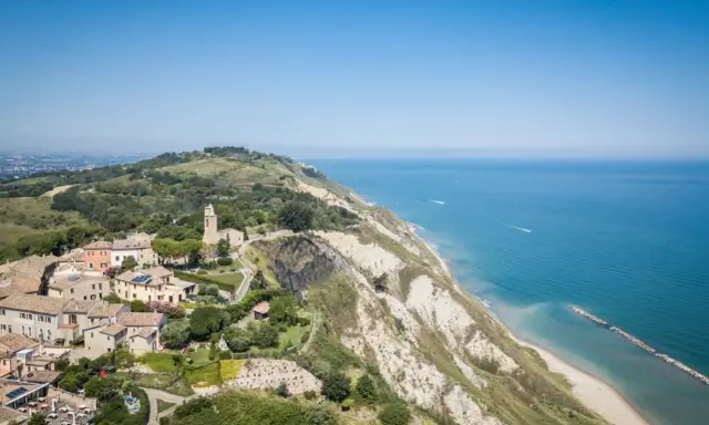 Panoramica aerea di Gabicce Mare, con case arroccate su una collina a picco sul mare Adriatico.