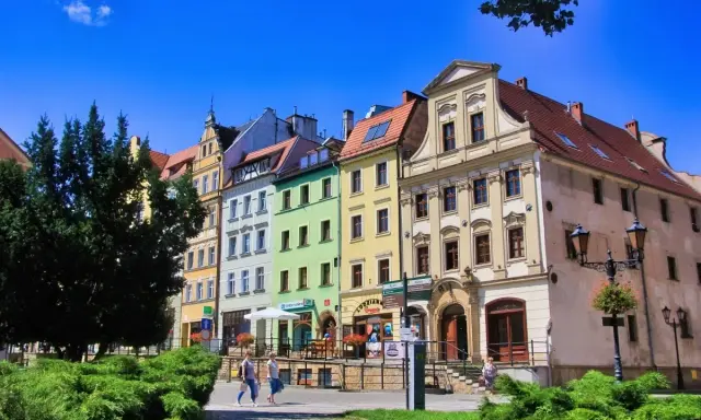 Kolorowe kamienice na rynku w Złotoryi, zachęcające do odkrywania urokliwych zakątków i atrakcji miasta.