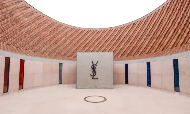 Logo Yves Saint Laurent nel **museo Yves Saint Laurent Marrakech**, con pareti in mattoni e vetrate colorate.