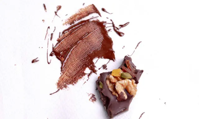 Manchas de chocolate derretido y trozo de chocolate con frutos secos. ¿Cómo quitar manchas que no sabes de qué son?