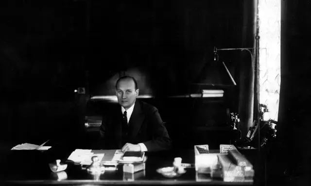 Ivar Kreuger, en svensk ingenjör och industriman, sitter vid sitt skrivbord. En scen som skulle kunna vara från en **Ivar Kreuger film**.