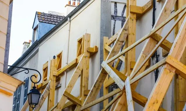 Estructura de madera para apuntalar una fachada, un ejemplo de apeo que significa soporte y seguridad.