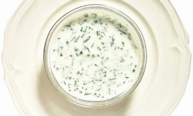 En skål med krämig kall sås till fisk, med finhackade örter som dill och gräslök. Perfekt till sommarens sillbord.