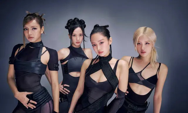 Medlemmar av Blackpink poserar i futuristiska svarta outfits.