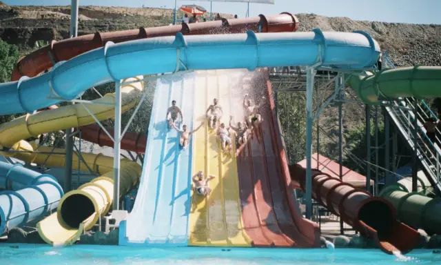 Gente disfrutando de toboganes de agua en lo que parece ser el mejor parque acuático de Europa.