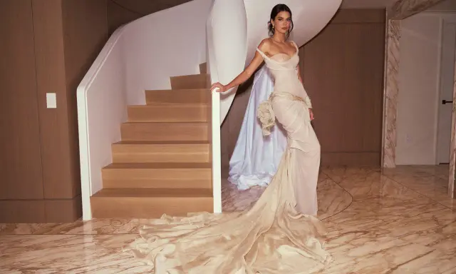 Kendall Jenner in a flowing gown, posing by a spiral staircase, a vision of Met Gala elegance.