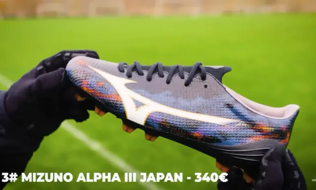 Ręce w rękawiczkach trzymają kolorowe korki Mizuno Alpha III Japan, które mogą być najlepszymi korkami na świecie.