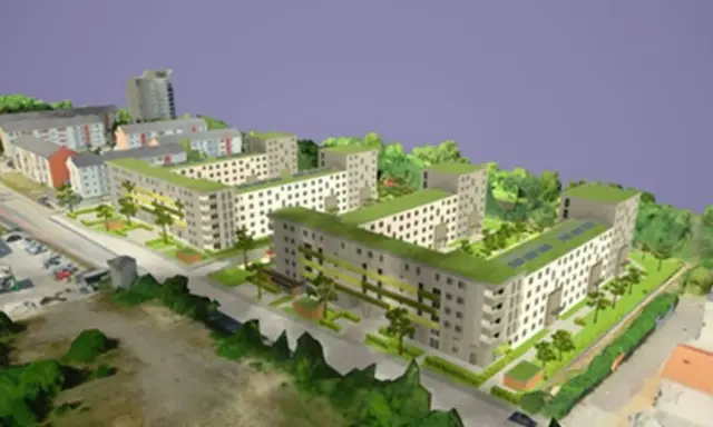 Modell einer integrierten Stadtentwicklung mit begrünten Dächern, Wohnblöcken und Bäumen.