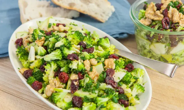 Frischer Brokkolisalat mit Cranberries und Walnüssen. Ein köstliches, **high protein vegetarisch** Gericht, serviert mit Brot.