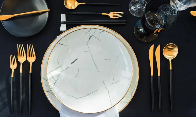 Une table dressée avec élégance, évoquant une ancienne tradition française. Vaisselle moderne aux accents dorés, prête pour un repas raffiné.
