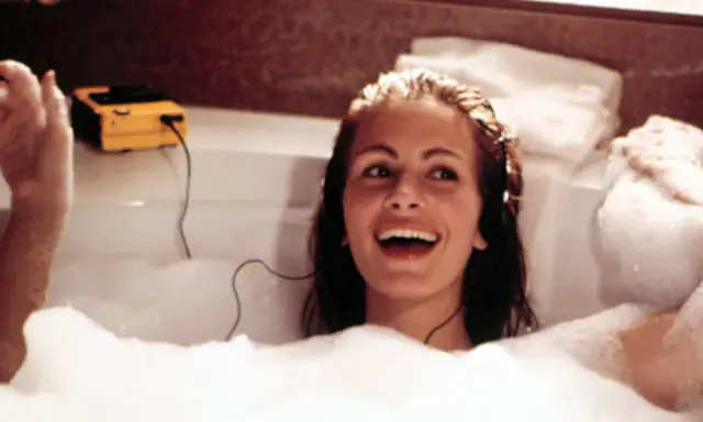 Julia Roberts lacht in einer Schaumbadewanne, hört Musik über Kopfhörer. Sie fragt sich, wie oft Haare waschen wohl nötig ist, um so strahlend auszusehen.