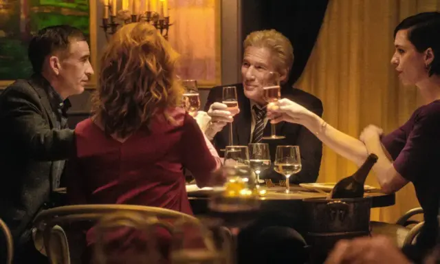 Quattro persone brindano durante una cena elegante, con bicchieri di champagne e un'atmosfera intima.