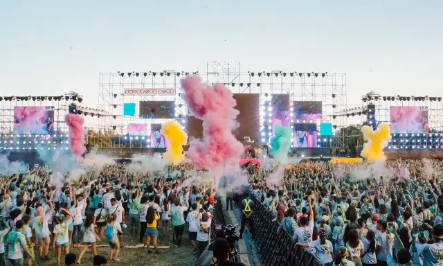 Stor publik njuter av Way Out West lineup med färgpulver i luften.