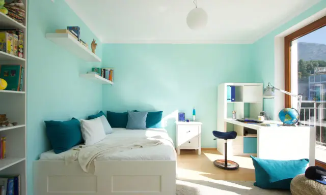 Habitación juvenil con paredes en colores combinar verde menta y azul turquesa en cojines y accesorios.
