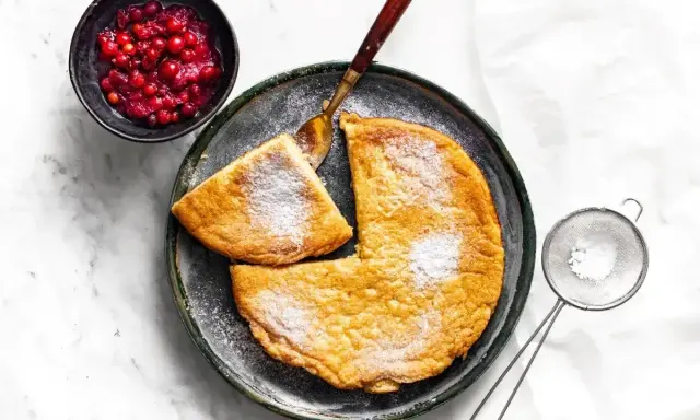 Puszysty omlet z airfryer, posypany cukrem pudrem, podany z żurawiną. Idealny na śniadanie.