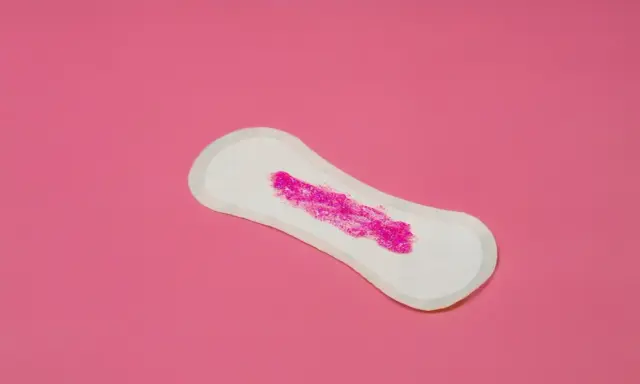 Compresa con brillo rosa simulando que la regla solo mancho al limpiarme.