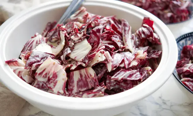 Ein cremiger Radicchio Salat in einer weißen Schüssel, bereit zum Servieren.