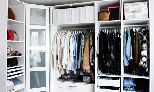 Ordentliche Kleideraufteilung im PAX Kleiderschrank: Hängende Kleidung, Taschen und Boxen sind übersichtlich sortiert.