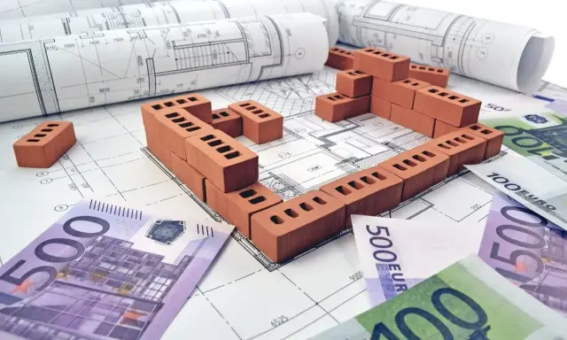 Plans de maison, briques et billets en euros symbolisant le prix construction maison 150m2.