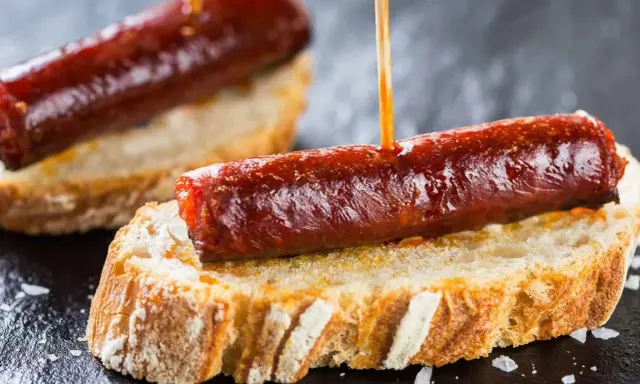 Pinchos de chorizo, un clásico de la comida típica de Navarra, servidos sobre pan rústico.