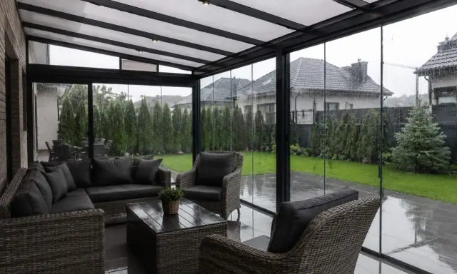 Wygodne meble wypoczynkowe na zadaszonym tarasie, idealne na deszczowy dzień.