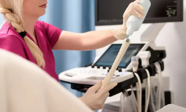 Lekarka przygotowuje sondę USG, aplikując żel. Badanie oceni m.in. grubość endometrium normy.
