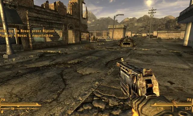 Pustynny krajobraz z ruiny miasta, gracz trzyma broń. W rogu ekranu widać tekst z gry, który sugeruje, że to **fallout new vegas spolszczenie**.