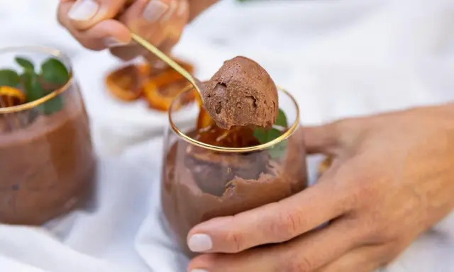 Delicioso mousse de chocolate, perfecto para los postres de Nochevieja. Una cucharada dorada revela su textura aireada.