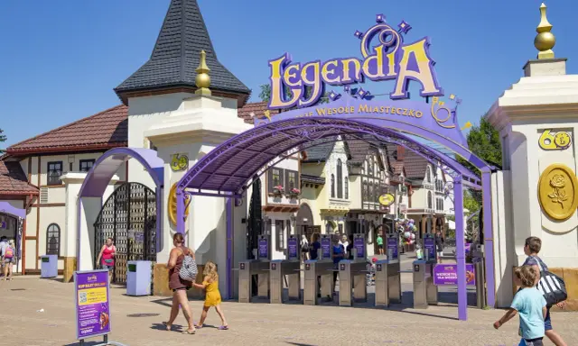 Wejście do Legendii, jednego z najpopularniejszych parków rozrywki w Polsce. Rodziny wchodzą przez bramki.