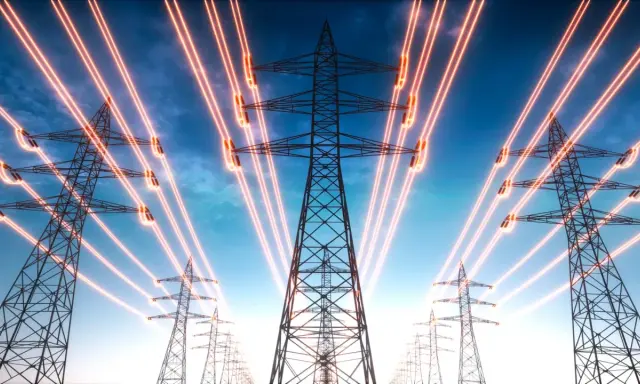 Strommasten mit leuchtenden Leitungen, die eine steigende strompreisentwicklung bis 2035 symbolisieren.