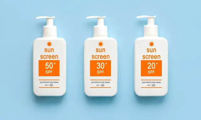 Trois bouteilles de crème solaire avec des indices SPF variés (50+, 30+, 20+). Le SPF signification est la protection contre les rayons du soleil.