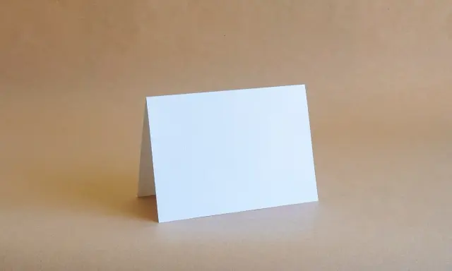 Biała kartka formatu B6 (12,5 x 17,6 cm) złożona na pół, gotowa na Twoje życzenia.