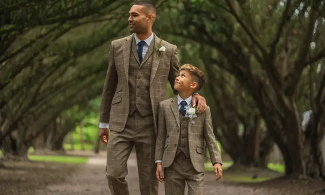 A man and boy in matching tweed suits, a perfect example of what formal attire means for a wedding.