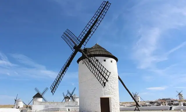 Molinos de viento blancos bajo un cielo azul. Un lugar que ver en Ciudad Real, como sacado de un cuento.