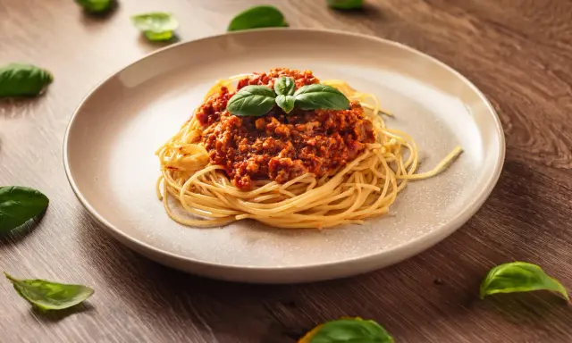 Pyszne spaghetti bolognese, idealne na prosty obiad. Aromatyczny sos mięsny z pomidorami i świeża bazylia.