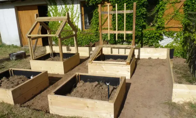 Nouveau potager en carré prêt à être planté. Structures en bois pour protéger les futures cultures.