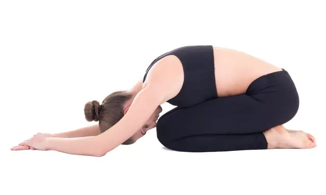 Frau in Kindhaltung, die bei Hexenschuss wie schlafen hilft. Entspannende Yoga-Pose für den Rücken.