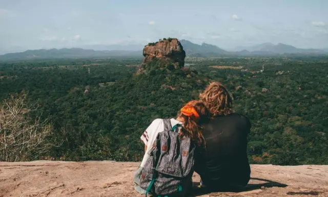 Coppia ammira Sigiriya, una delle meraviglie da vedere in Sri Lanka. Paesaggio lussureggiante e roccia imponente.