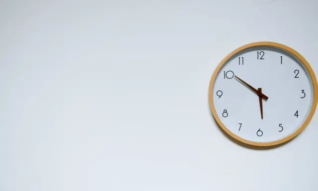 Reloj de pared blanco con marco de madera. Las manecillas marcan las 10:05, un momento clave para mi ayuno de 17 horas.