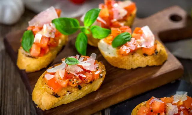Bruschetta med färska tomater, basilika och parmesan på rostat bröd. Ett enkelt och gott bruschetta recept för alla tillfällen.